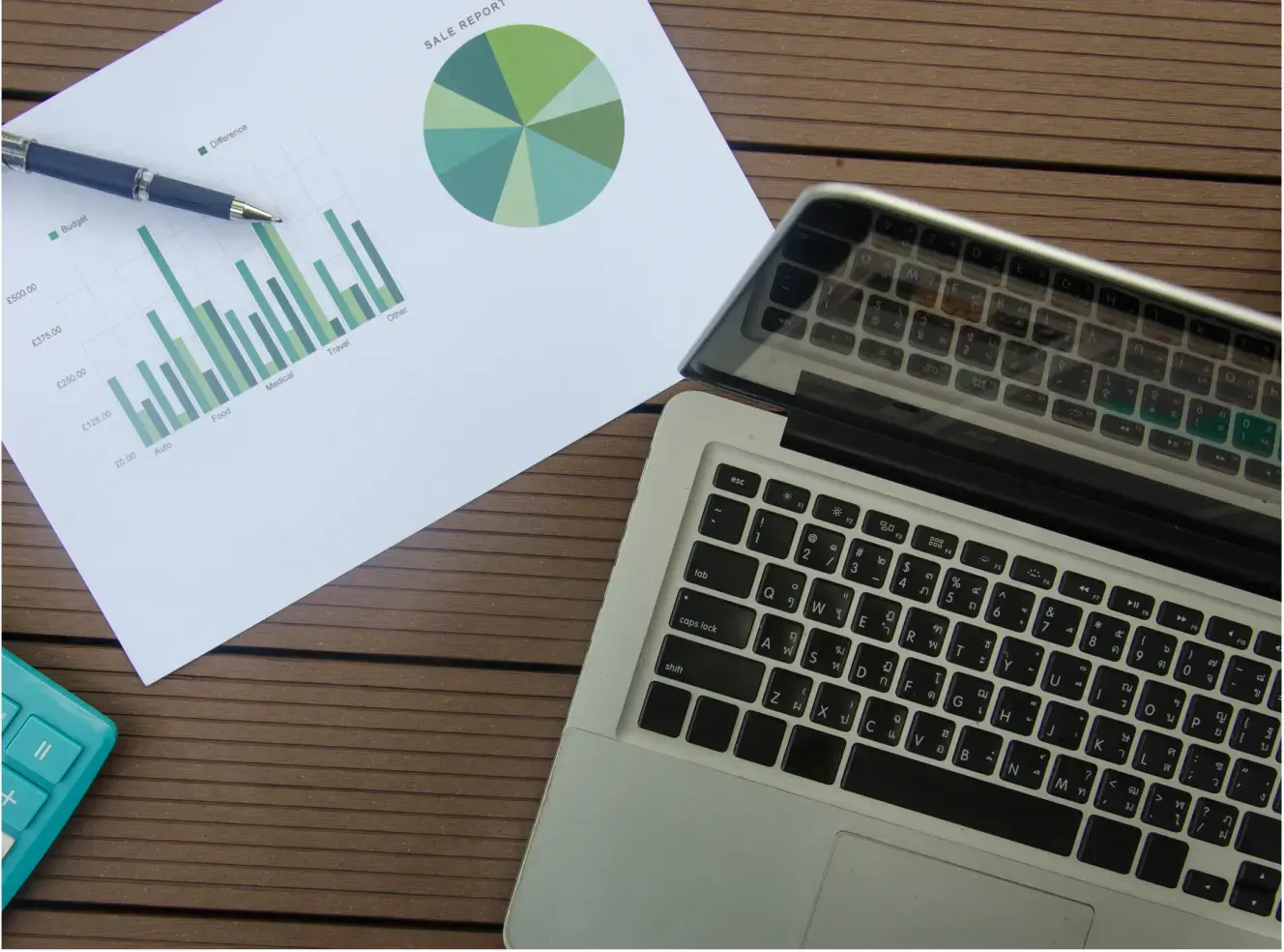 Energy reports and charts beside a laptop