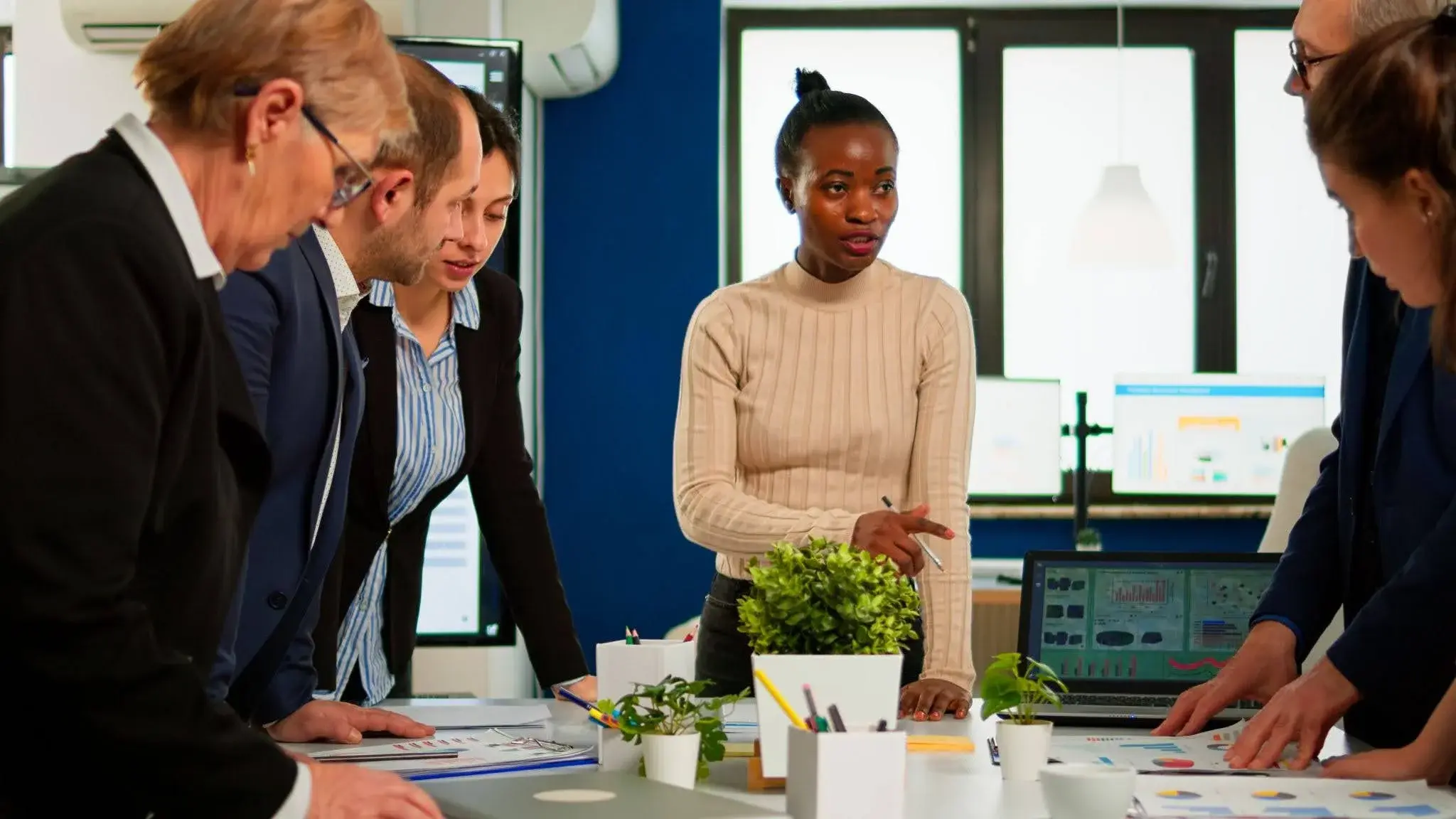 Managers in an office talking about a potential workforce development programme, and trying to figure out which employees could benefit the most from it.